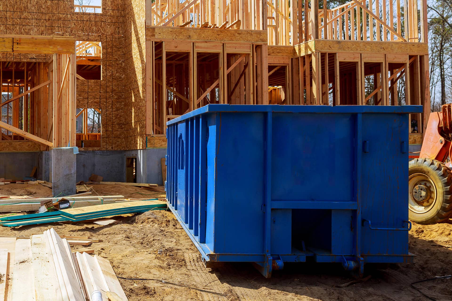 A Blue Container In Front Of A Building Under Construction