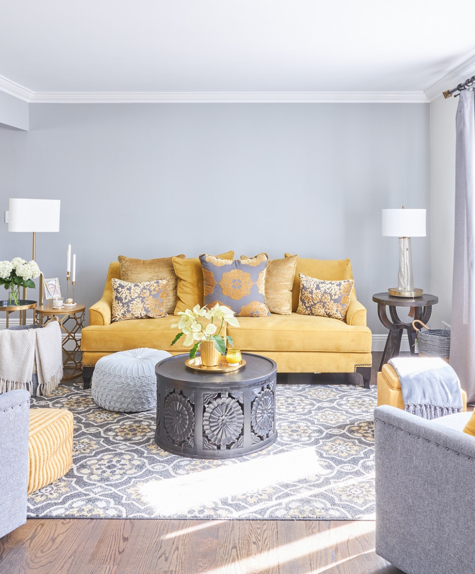 A Living Room With A Yellow Couch And A Coffee Table