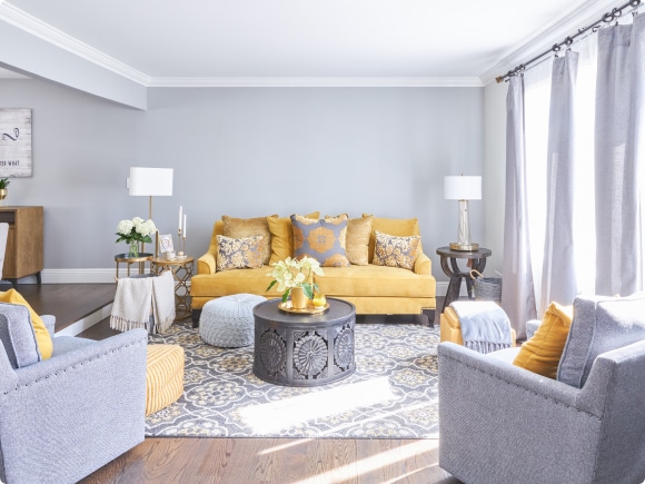 A Living Room With A Yellow Couch And A Coffee Table