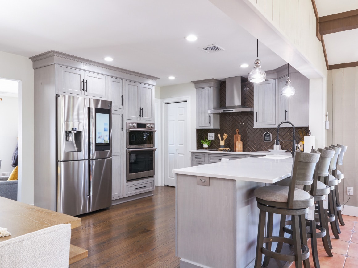 A Kitchen With White Cabinets And A Wood Floor